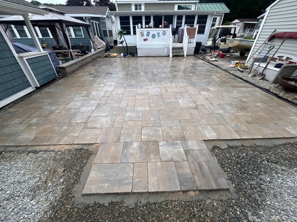 Newly installed paver patio with a smooth surface and surrounding landscaping.